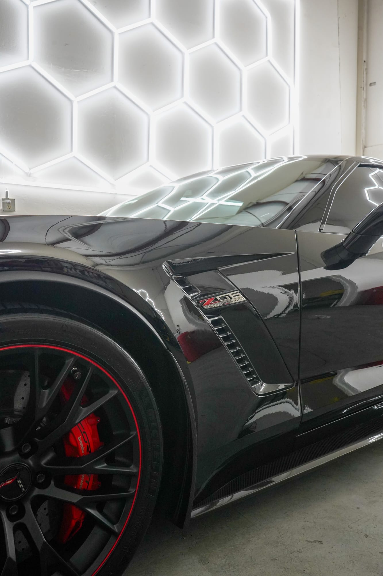 Side of a Corvette Z06 after a ceramic coating, red brake calipers and hex lights