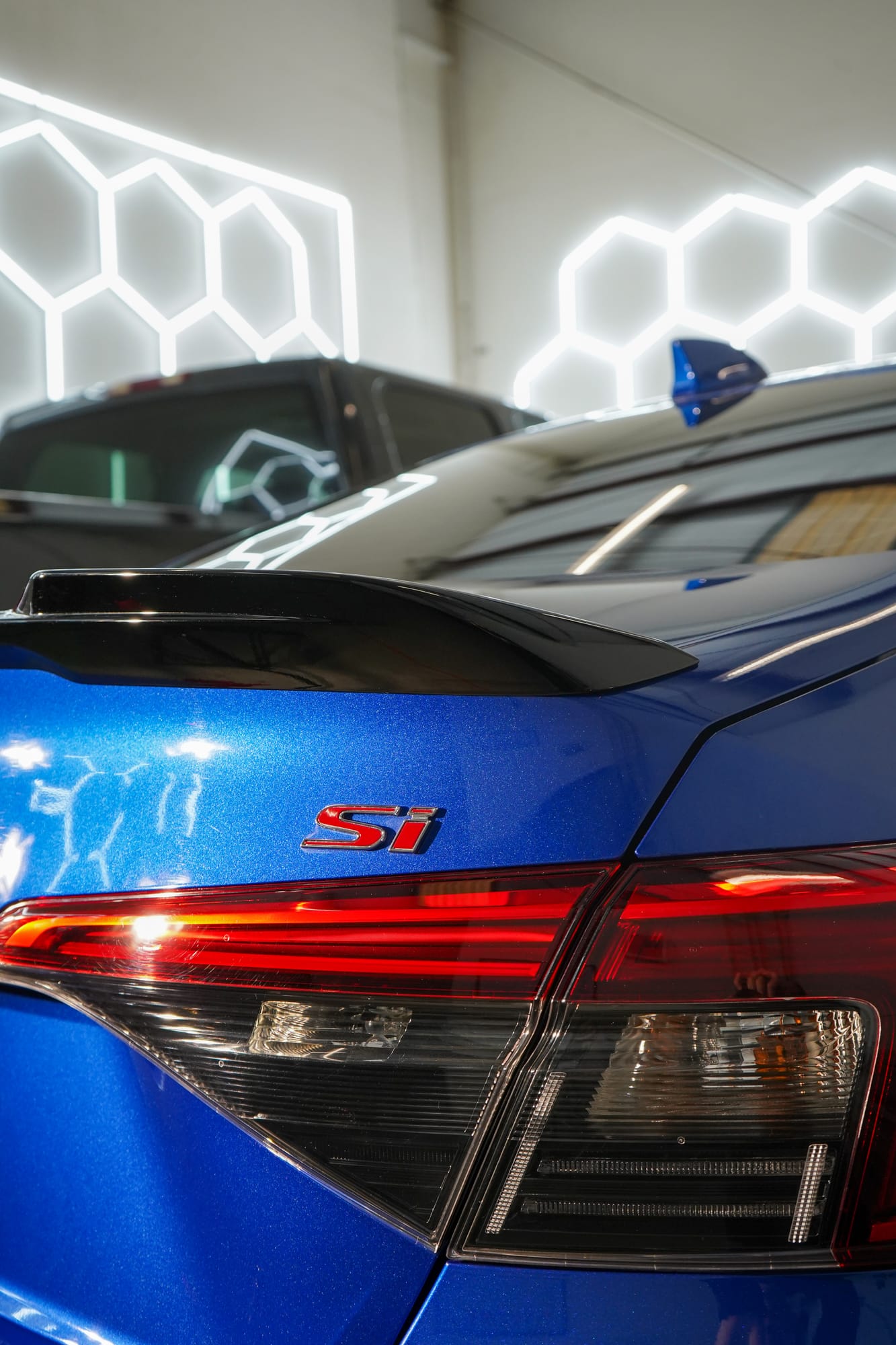 Close up of a blue Honda Civic Si's rear and Si badge after a ceramic coating