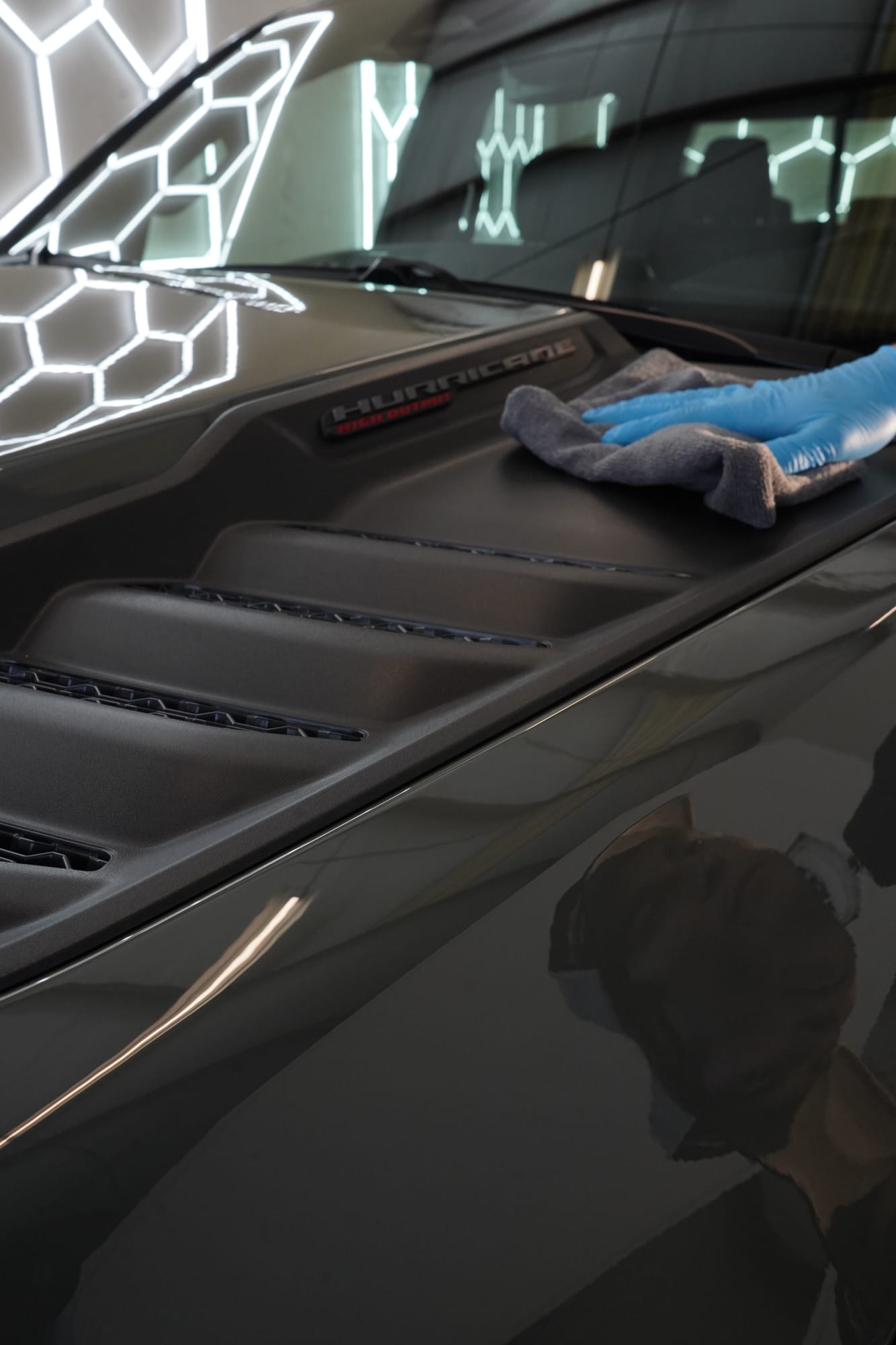 Close up of a blue towel levelling a fresh ceramic coating on a Ram RHO hood
