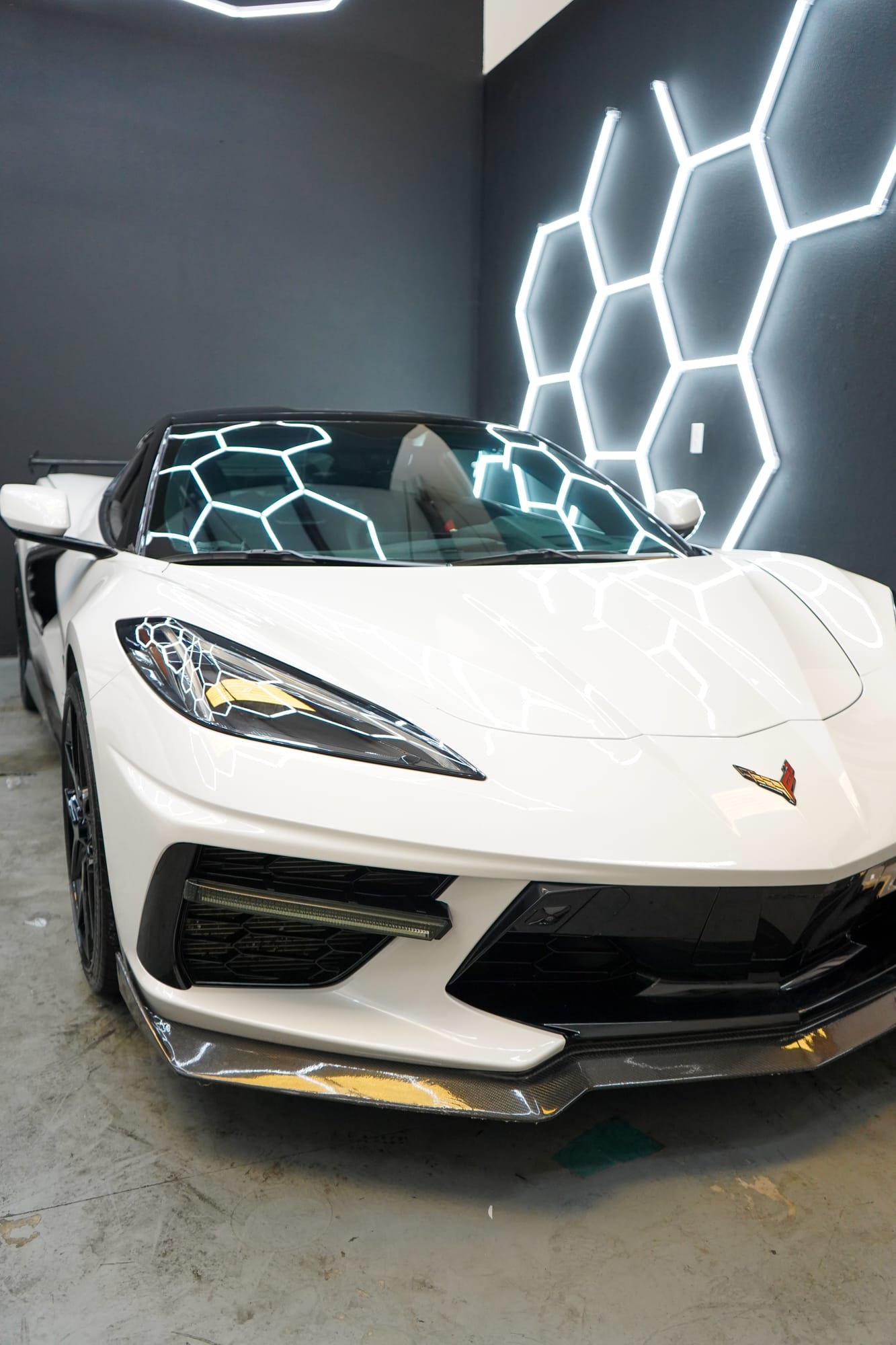 White Corvette 70th Anniversary Edition with paint protection film and color change film, under the shop's hex lights
