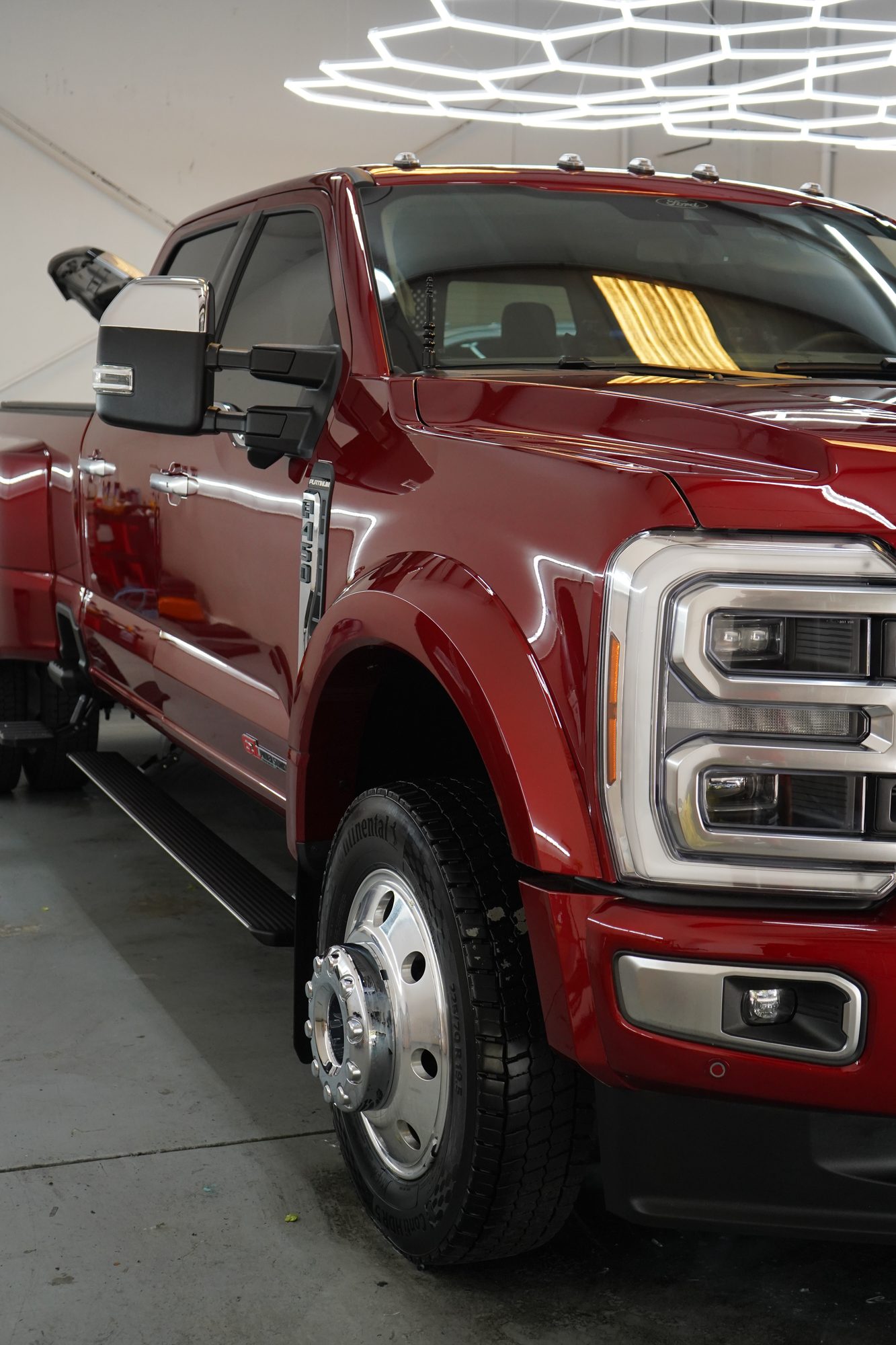 Red Ford F-450 Platinum dually, front three-quarter, in the Oakdale shop for paint protection film
